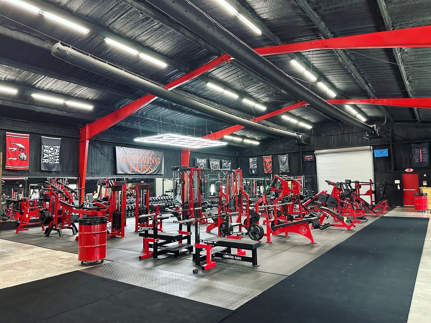 Weight racks and barbells inside Growing Pains Gym in Tifton, GA